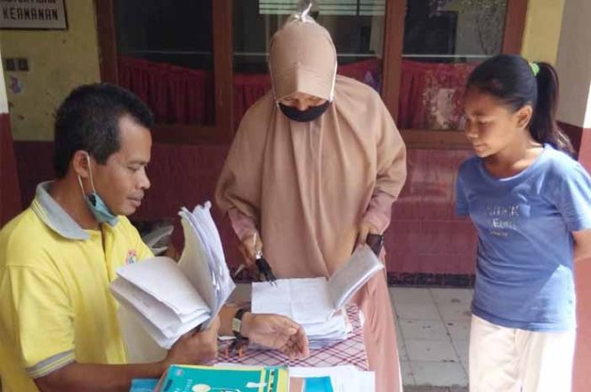 
					Ditemani wali murid, seorang siswa menyerahkan hasil kegiatan Pesantren Virtual di Ramadan.